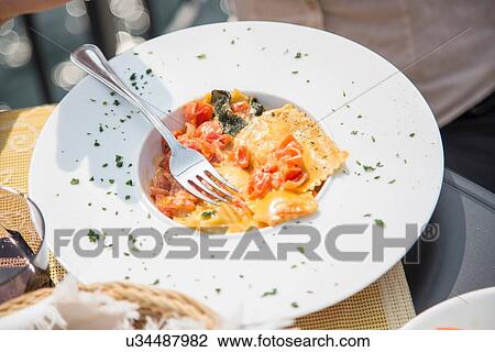 Plate of fresh ravioli on restaurant table View Large Photo Image Stock Image - Plate of fresh ravioli on restaurant table. Fotosearch