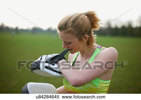 Portrait of a woman putting on boxing pads in the park View Large Photo Image Stock Photography - Portrait of a woman putting on boxing pads in the park. Fotosearch