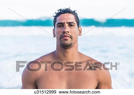 Stock Photo - Portrait of barechested, mid adult man by sea. Fotosearch