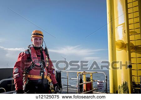 Stock Photography - Portrait of engineer at sea at offshore wind farm. Fotosearch