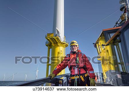 Stock Photo - Portrait of engineer on boat on offshore wind farm. Fotosearch