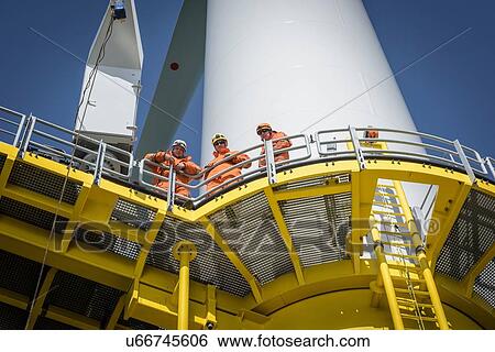 Stock Photograph - Portrait of engineers on wind turbine on offshore wind farm. Fotosearch