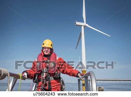 Stock Image - Portrait of female engineer on boat at offshore windfarm. Fotosearch