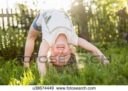 Portrait of girl bending over backwards upside down in garden View Large Photo Image Stock Photo - Portrait of girl bending over backwards upside down in garden. Fotosearch