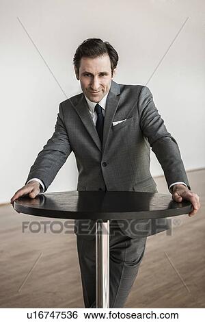 Portrait of mature businessman, leaning on round table View Large Photo Image Stock Photograph - Portrait of mature businessman, leaning on round table. Fotosearch