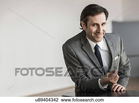 Stock Image - Portrait of mature businessman, smiling. Fotosearch