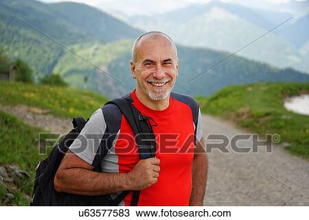 Stock Image - Portrait of mature male hiker on rural road, Grigna, Lecco, Lombardy, Italy. Fotosearch