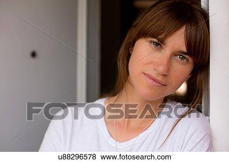 Portrait of mid adult woman leaning against doorframe, looking at camera View Large Photo Image Stock Photo - Portrait of mid adult woman leaning against doorframe, looking at camera. Fotosearch