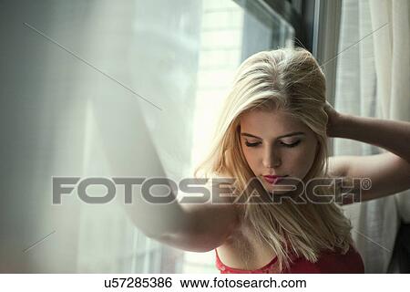 Portrait of sultry young woman at apartment window View Large Photo Image Stock Photograph - Portrait of sultry young woman at apartment window. Fotosearch