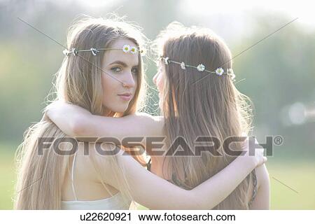 Portrait of two teenage girls wearing daisy chain headdresses in park View Large Photo Image Stock Image - Portrait of two teenage girls wearing daisy chain headdresses in park. Fotosearch