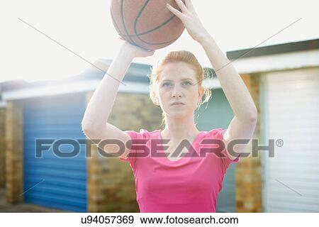 Portrait of woman holding basketball above head View Large Photo Image Stock Photo - Portrait of woman holding basketball above head. Fotosearch