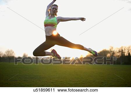 Portrait of woman jumping in park View Large Photo Image Stock Image - Portrait of woman jumping in park. Fotosearch