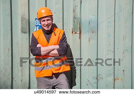 Portrait of worker wearing protective workwear in front of wooden door View Large Photo Image Stock Photo - Portrait of worker wearing protective workwear in front of wooden door. Fotosearch