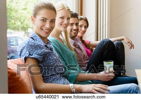 Portrait of young adults friends on cafe sofa View Large Photo Image Stock Image - Portrait of young adults friends on cafe sofa. Fotosearch