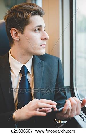 Portrait of young businessman commuter using digital tablet on train. View Large Photo Image Stock Photo - Portrait of young businessman commuter using digital tablet on train.. Fotosearch