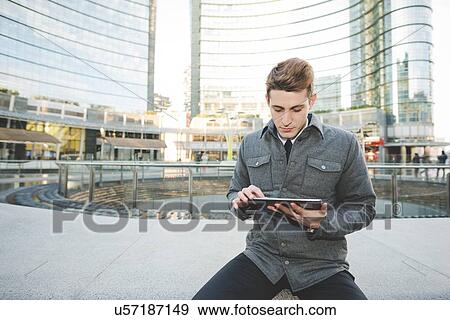 Stock Photo - Portrait of young businessman commuter using digital tablet.. Fotosearch