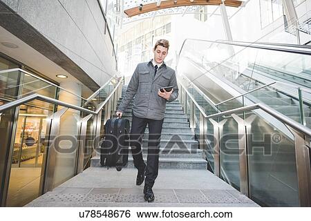 Portrait of young businessman commuter using digital tablet. View Large Photo Image Stock Photograph - Portrait of young businessman commuter using digital tablet.. Fotosearch