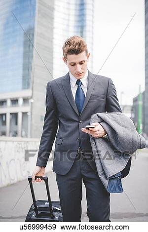 Stock Photo - Portrait of young businessman using mobile phone.. Fotosearch