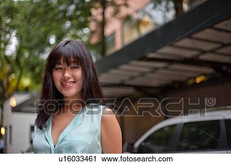 Stock Image - Portrait of young businesswoman, smiling, Shanghai, China. Fotosearch