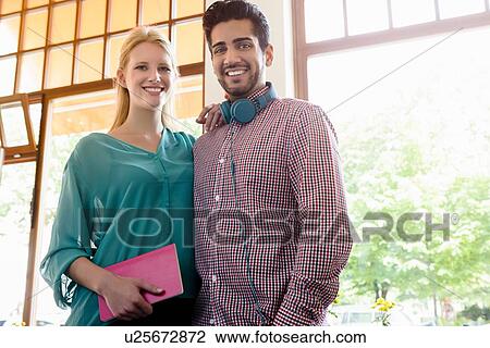 Stock Image - Portrait of young couple in cafe. Fotosearch