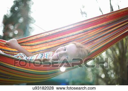 Stock Photo - Portrait of young girl on garden hammock. Fotosearch