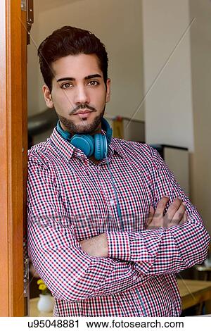 Portrait of young man with arms folded in cafe doorway View Large Photo Image Stock Image - Portrait of young man with arms folded in cafe doorway. Fotosearch