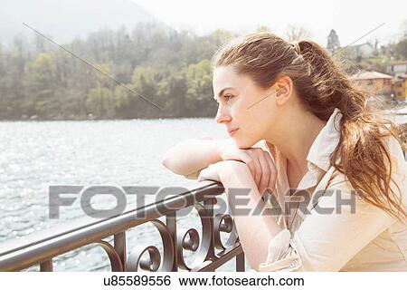 Portrait of young woman gazing from lakeside, Lake Mergozzo, Verbania, Piemonte, Italy View Large Photo Image Stock Photograph - Portrait of young woman gazing from lakeside, Lake Mergozzo, Verbania, Piemonte, Italy. Fotosearch