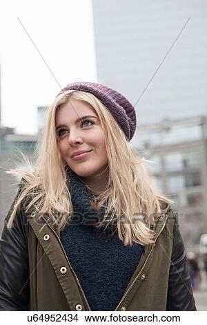 Picture - Portrait of young woman looking up from street, New York, USA. Fotosearch
