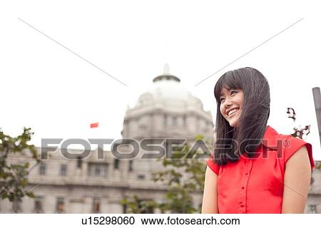 Stock Image - Portrait of young woman, outdoors, Shanghai, China. Fotosearch