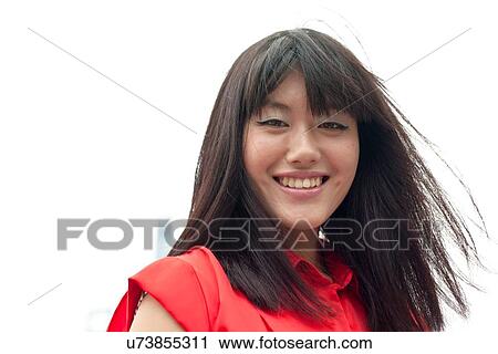 Stock Image - Portrait of young woman, outdoors, Shanghai, China. Fotosearch