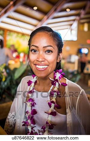 Stock Image - Portrait of young woman wearing flower lei in Polynesian Cultural Centre, Hawaii, USA. Fotosearch
