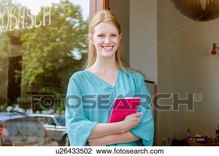 Portrait of young woman with notebook in cafe doorway View Large Photo Image Stock Image - Portrait of young woman with notebook in cafe doorway. Fotosearch