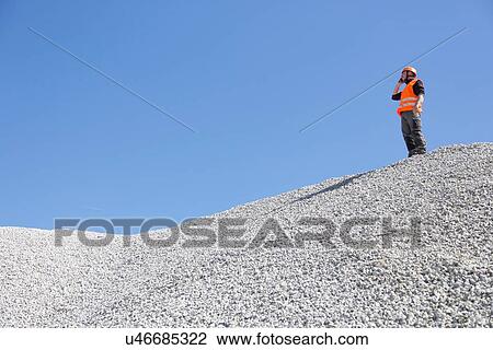 Quarry worker chatting on smartphone from quarry gravel mound View Large Photo Image Stock Image - Quarry worker chatting on smartphone from quarry gravel mound. Fotosearch