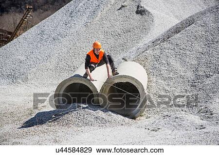 Quarry worker measuring industrial pipes at quarry View Large Photo Image Stock Photo - Quarry worker measuring industrial pipes at quarry. Fotosearch
