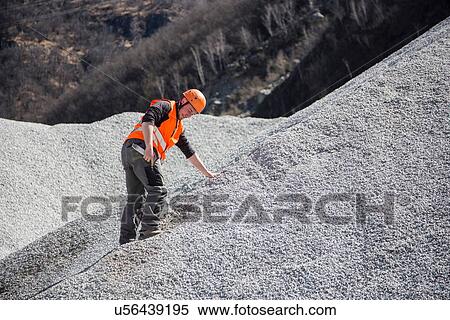 Quarry worker measuring on gravel mound at quarry View Large Photo Image Stock Photography - Quarry worker measuring on gravel mound at quarry. Fotosearch