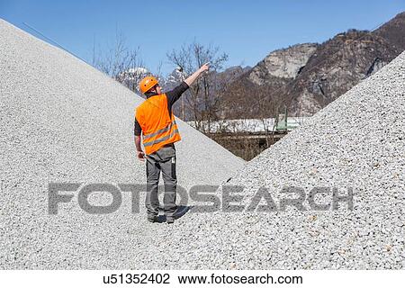 Quarry worker pointing from gravel mounds at quarry View Large Photo Image Stock Image - Quarry worker pointing from gravel mounds at quarry. Fotosearch