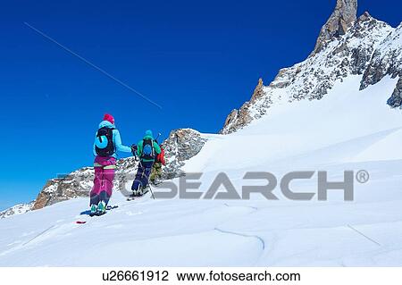 Rear view of mature male and female skiers moving up Mont Blanc massif, Graian Alps, France View Large Photo Image Stock Image - Rear view of mature male and female skiers moving up Mont Blanc massif, Graian Alps, France. Fotosearch
