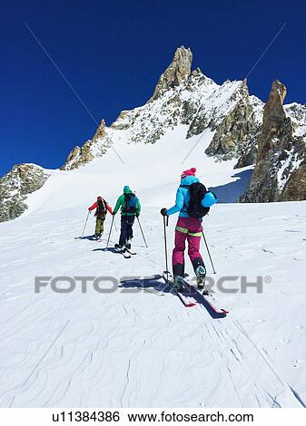 Rear view of three adult skiers moving up Mont Blanc massif, Graian Alps, France View Large Photo Image Stock Photograph - Rear view of three adult skiers moving up Mont Blanc massif, Graian Alps, France. Fotosearch