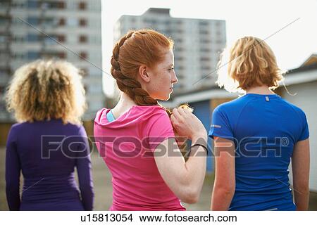 Rear view of three women standing together wearing sports clothing View Large Photo Image Picture - Rear view of three women standing together wearing sports clothing. Fotosearch