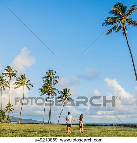 Rear view of young couple strolling near Kaaawa beach, Oahu, Hawaii, USA View Large Photo Image Stock Photo - Rear view of young couple strolling near Kaaawa beach, Oahu, Hawaii, USA. Fotosearch
