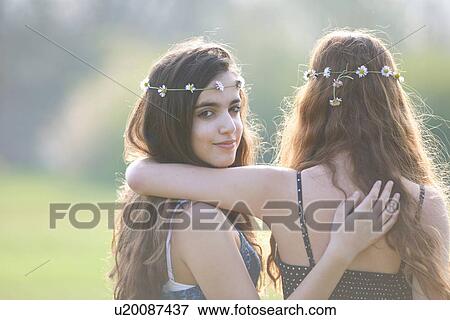 Rear view portrait of two teenage girls wearing daisy chain headdresses in park View Large Photo Image Stock Photo - Rear view portrait of two teenage girls wearing daisy chain headdresses in park. Fotosearch