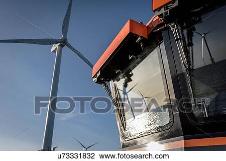 Stock Image - Reflections of offshore wind farm on boat at sea. Fotosearch