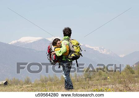 Romantic male hiker carrying girlfriend in arms, Vogogna, Verbania, Piemonte, Italy View Large Photo Image Stock Image - Romantic male hiker carrying girlfriend in arms, Vogogna, Verbania, Piemonte, Italy. Fotosearch