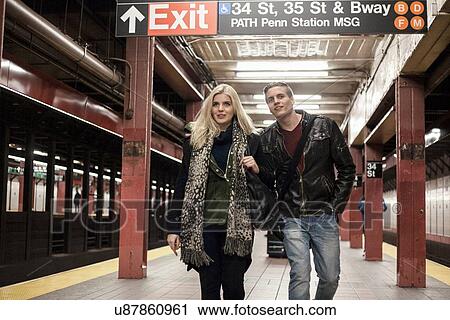 Romantic young couple strolling arm in arm on New York City subway platform, New York, USA View Large Photo Image Stock Image - Romantic young couple strolling arm in arm on New York City subway platform, New York, USA. Fotosearch