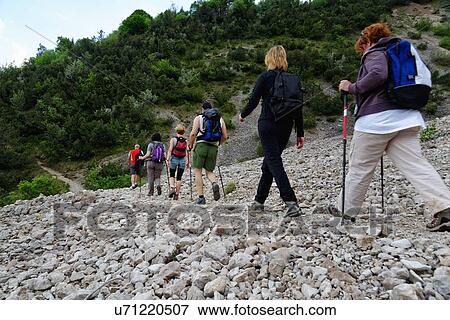 Row of six male and female mature hikers hiking in stoney valley View Large Photo Image Stock Photo - Row of six male and female mature hikers hiking in stoney valley. Fotosearch