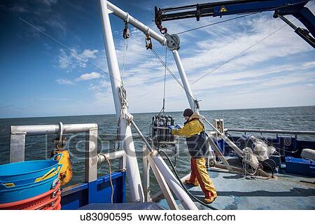 Scientist lowering sea water sampling experiment into sea on research ship View Large Photo Image Stock Photography - Scientist lowering sea water sampling experiment into sea on research ship. Fotosearch