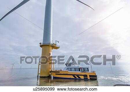 Service boat and wind turbine at offshore windfarm View Large Photo Image Stock Photo - Service boat and wind turbine at offshore windfarm. Fotosearch