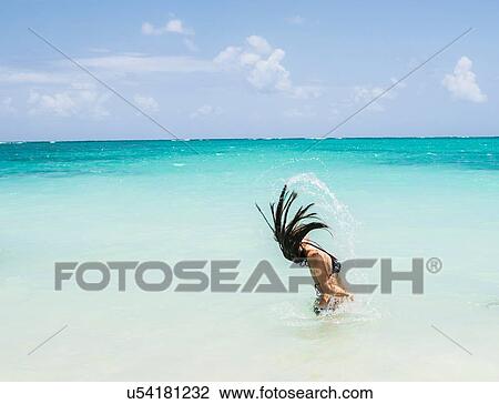 Side view of young woman throwing long wet hair back in sea at Lanikai Beach, Oahu, Hawaii, USA View Large Photo Image Stock Image - Side view of young woman throwing long wet hair back in sea at Lanikai Beach, Oahu, Hawaii, USA. Fotosearch