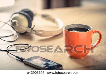 Stock Photography - Still life of black coffee, headphones and smartphone. Fotosearch