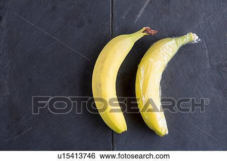 Still life of two bananas - one wrapped in plastic wrap View Large Photo Image Stock Photograph - Still life of two bananas - one wrapped in plastic wrap. Fotosearch